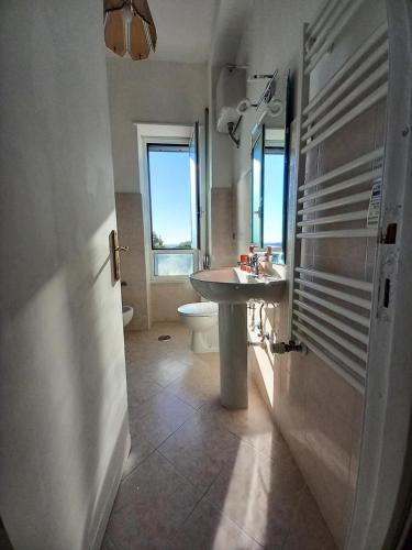 a bathroom with a sink and a toilet at Sunny Apt 20 min St Peter by train in Rome