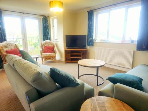 a living room with a couch and a tv at Relaxing coastal getaway in Mortehoe, Woolacombe in Mortehoe
