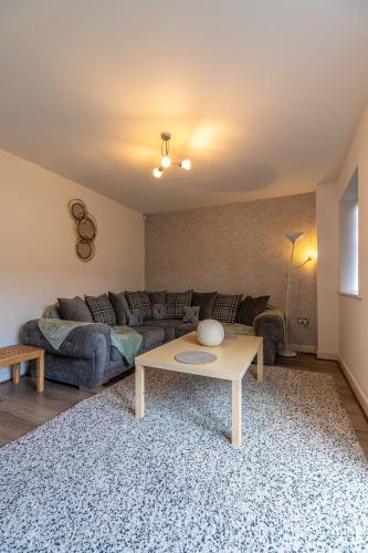 a living room with a couch and a coffee table at Cosy Modern 3-Bed Near Etihad, COOP Arena - AO arena and City Center in Manchester
