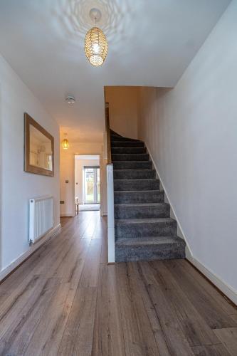 an empty hallway with stairs in a house at Cosy Modern 3-Bed Near Etihad, COOP Arena - AO arena and City Center in Manchester