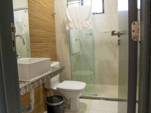 a bathroom with a toilet and a sink and a shower at Flat pé na areia na praia de Porto de Galinhas próximo as piscinas naturais. in Porto De Galinhas