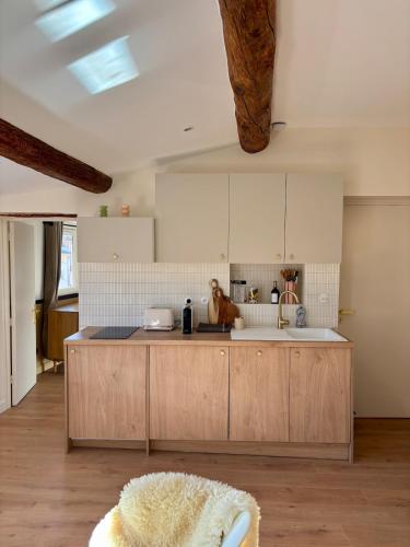 une cuisine avec des armoires en bois et un comptoir dans l'établissement Magnifique appartement 2 chambres Aix & Cours Mirabeau, à Aix-en-Provence