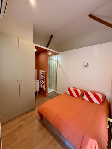 - une chambre avec un lit orange dans l'établissement Magnifique appartement 2 chambres Aix & Cours Mirabeau, à Aix-en-Provence