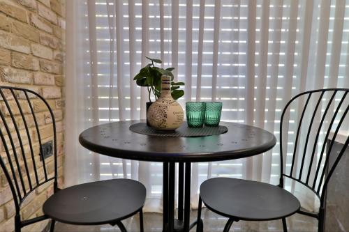 a round table with a vase and two chairs at שקיעה בים 75 - דירה מהממת עם ג'קוזי ספא ליד הים יש מקלט in Haifa