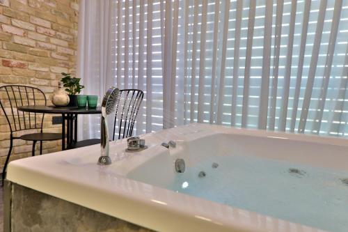 a bath tub with a sink in a room with a table at שקיעה בים 75 - דירה מהממת עם ג'קוזי ספא ליד הים יש מקלט in Haifa