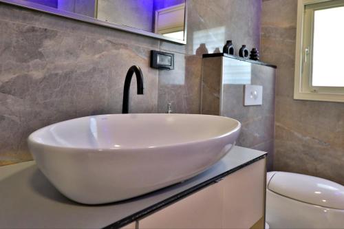 a bathroom with a large white sink and a toilet at שקיעה בים 75 - דירה מהממת עם ג'קוזי ספא ליד הים יש מקלט in Haifa