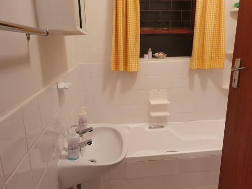 a bathroom with a sink and a bath tub at Betty's Bay Quaint Cottage in Bettyʼs Bay