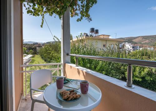 a table with a plate of food on a balcony at Hotel Peli in Kissamos