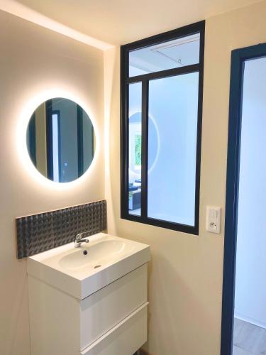 une salle de bain avec un lavabo et un miroir dans l'établissement Maison au calme à 2,4km de la mer, kids friendly, à Jullouville