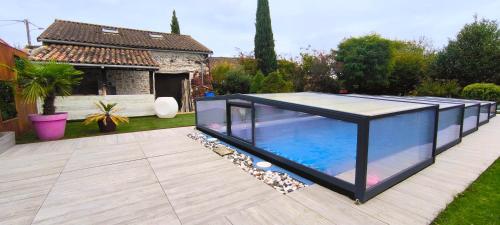 a swimming pool in a garden with a house at House 10 people, heated pool, countryside in Marthon