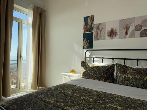 a bedroom with a bed and a large window at Casa Cibella Authentic Charme Apartments in Agrigento