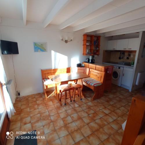 une cuisine avec une table et des chaises dans une pièce dans l'établissement Maison à 600 m de la plage, à Saint-Georges-de-Didonne