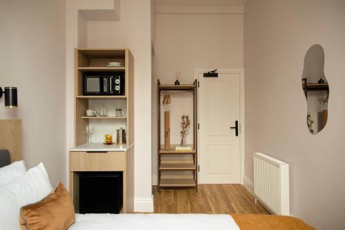 a bedroom with a bed and a sink and a mirror at Bob W London Olympia in London