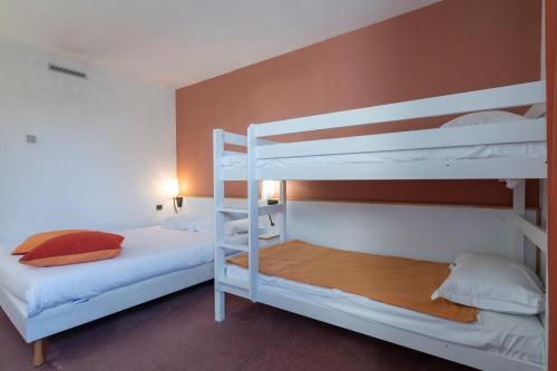 a bedroom with two bunk beds with white bunkitures at Hôtel Akena Poitiers Nord Futuroscope in Chasseneuil-du-Poitou