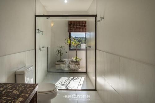 a bathroom with a toilet and a window at Casa com vista p mar em Garopaba PSV000 in Garopaba