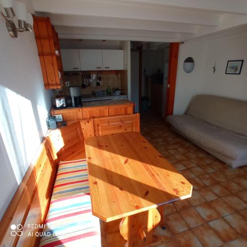 - un salon avec une table en bois et un canapé dans l'établissement Maison à 600 m de la plage, à Saint-Georges-de-Didonne