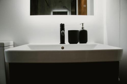 un lavandino bianco da bagno con due dispenser di sapone di Luxury 1 bedroom Glamping Cabin with Hot Tub & BBQ a Ballyvoy