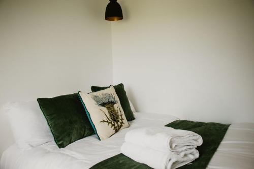 un letto con cuscini verdi e bianchi di Luxury 1 bedroom Glamping Cabin with Hot Tub & BBQ a Ballyvoy