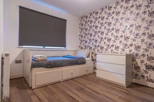 a bedroom with a bed and a large screen at Cosy Modern 3-Bed Near Etihad, COOP Arena - AO arena and City Center in Manchester