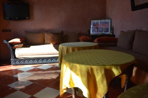 a living room with a couch and two tables at Riad Hôtel Belleville Marrakech in Marrakech