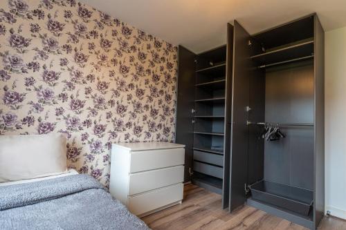 a bedroom with a bed and a closet at Cosy Modern 3-Bed Near Etihad, COOP Arena - AO arena and City Center in Manchester