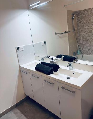 une salle de bain avec un lavabo blanc et un miroir dans l'établissement Cosy T3 Beauzelle proche MEETT, tram et aéroport, à Beauzelle