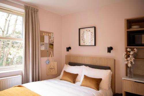 a bedroom with a bed with white sheets and a window at Bob W London Holland Park in London