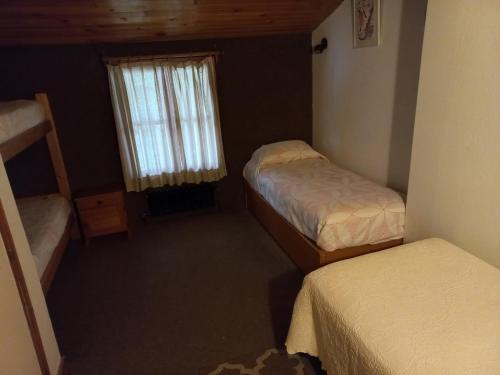a small room with two beds and a window at Casa Las Mutisias in San Martín de los Andes
