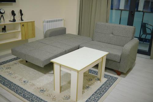 a living room with a couch and a coffee table at City Center Apartment in Kakhaberi