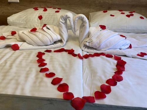 a bed with hearts on the sheets at Erdővarázs Panzió in Lillafüred