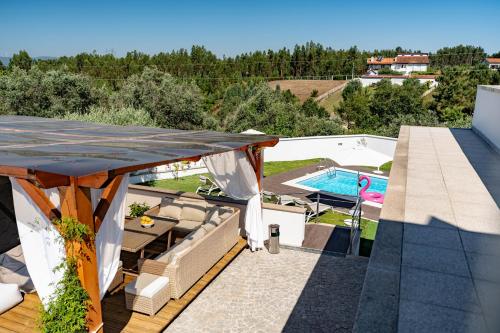 a patio with a table and a swimming pool at Alojamento Jasmine in São Pedro de Alva