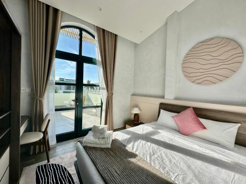 a bedroom with a bed and a large window at Meridian apartment service at Marina Long beach Phu Quoc in Phú Quốc