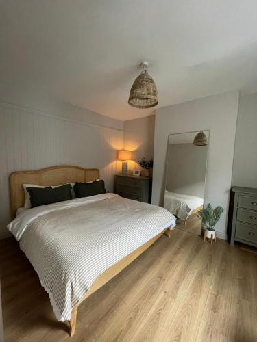 a bedroom with a large bed and a mirror at Nala's Nest in Hexham