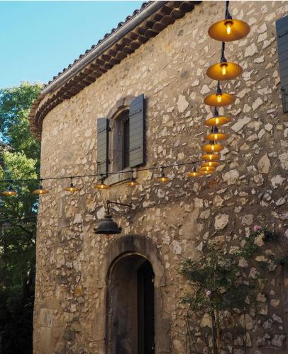 - un bâtiment en pierre avec des lumières sur le côté dans l'établissement Maison Paulette, à Eygalières