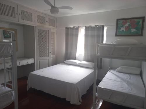 a bedroom with two bunk beds and a window at Pousada Rota do Sol in Cabo Frio