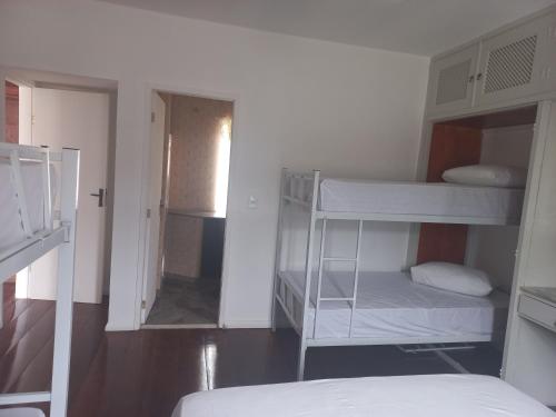 a room with two bunk beds and a mirror at Pousada Rota do Sol in Cabo Frio