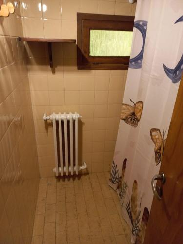 a bathroom with a radiator and a tiled floor at Casa Las Mutisias in San Martín de los Andes