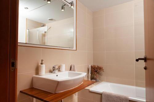 a bathroom with a sink and a mirror and a tub at Apartamento La Cala Azul en Miami in Miami Platja