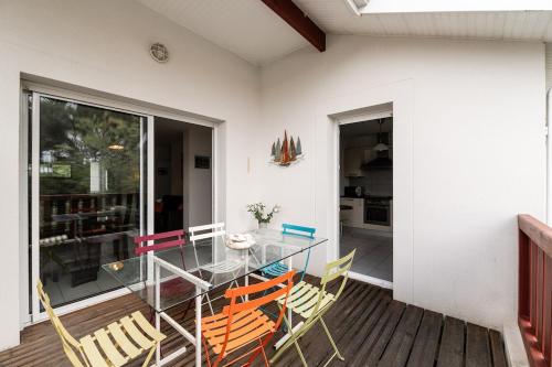 une salle à manger avec une table et des chaises en verre dans l'établissement Maison de vacances Navarrosse, à Biscarrosse