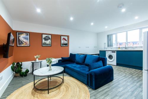 ein Wohnzimmer mit einem blauen Sofa und einem Tisch in der Unterkunft Chapel Street Apartments - Great Transport & Local Amenities in Long Eaton