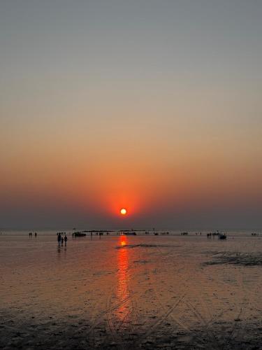 a sunset on a beach with the sun setting at Hireath! in Kelve Road