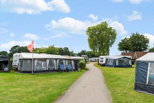 a group of tents in a field with a path at First Camp Frigård Camping & Cottages in Kruså