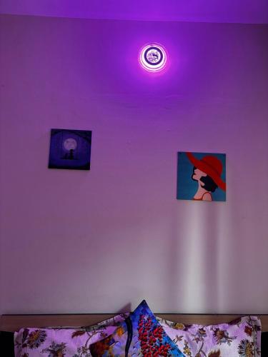a purple light on a ceiling with pictures and a couch at Hireath! in Kelve Road