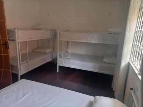 a bedroom with white shelves and a bed at Pousada Rota do Sol in Cabo Frio