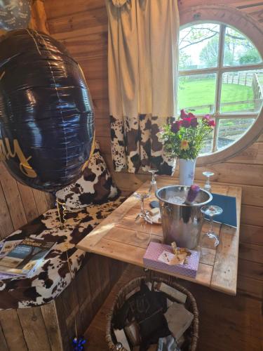 a room with a wooden table with a balloon and flowers at Burtree Country House, Tipi's, Treehouse & Lodge & house rooms with hot tubs in a private garden in Thirsk