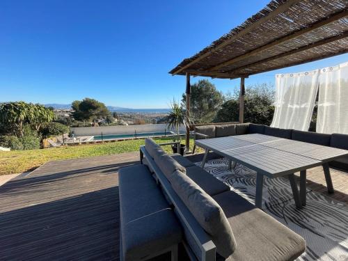 une terrasse en bois avec une table et un banc dans l'établissement Villa Paloma - Great location - Sea View - Alps, à Antibes