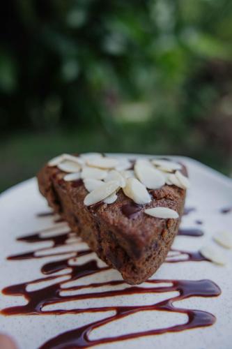 a piece of cake with nuts on top on a plate at Salvia Madre Hotel Boutique in Guachaca