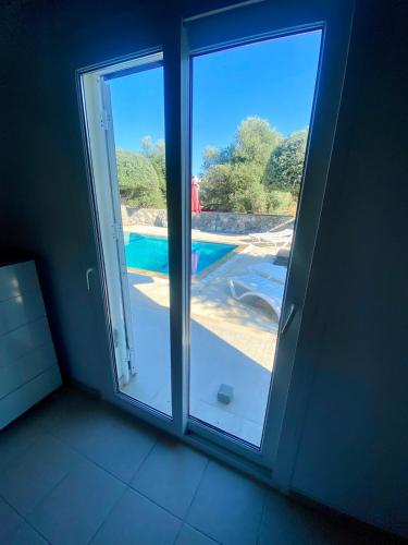 a room with two sliding doors with a view of a pool at The Bungalow Kyrenia North Cyprus in Ayios Ioannis