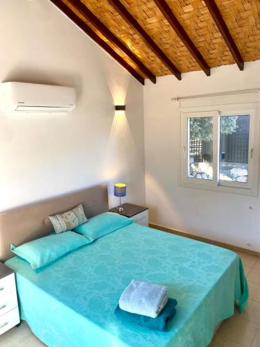 a bedroom with a blue bed with a window at The Bungalow Kyrenia North Cyprus in Ayios Ioannis