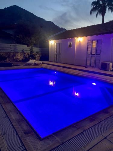 a blue swimming pool at night with a house at The Bungalow Kyrenia North Cyprus in Ayios Ioannis